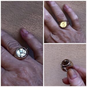 A Anello in bronzo giallo con centrale che ruota e simboli da architettp